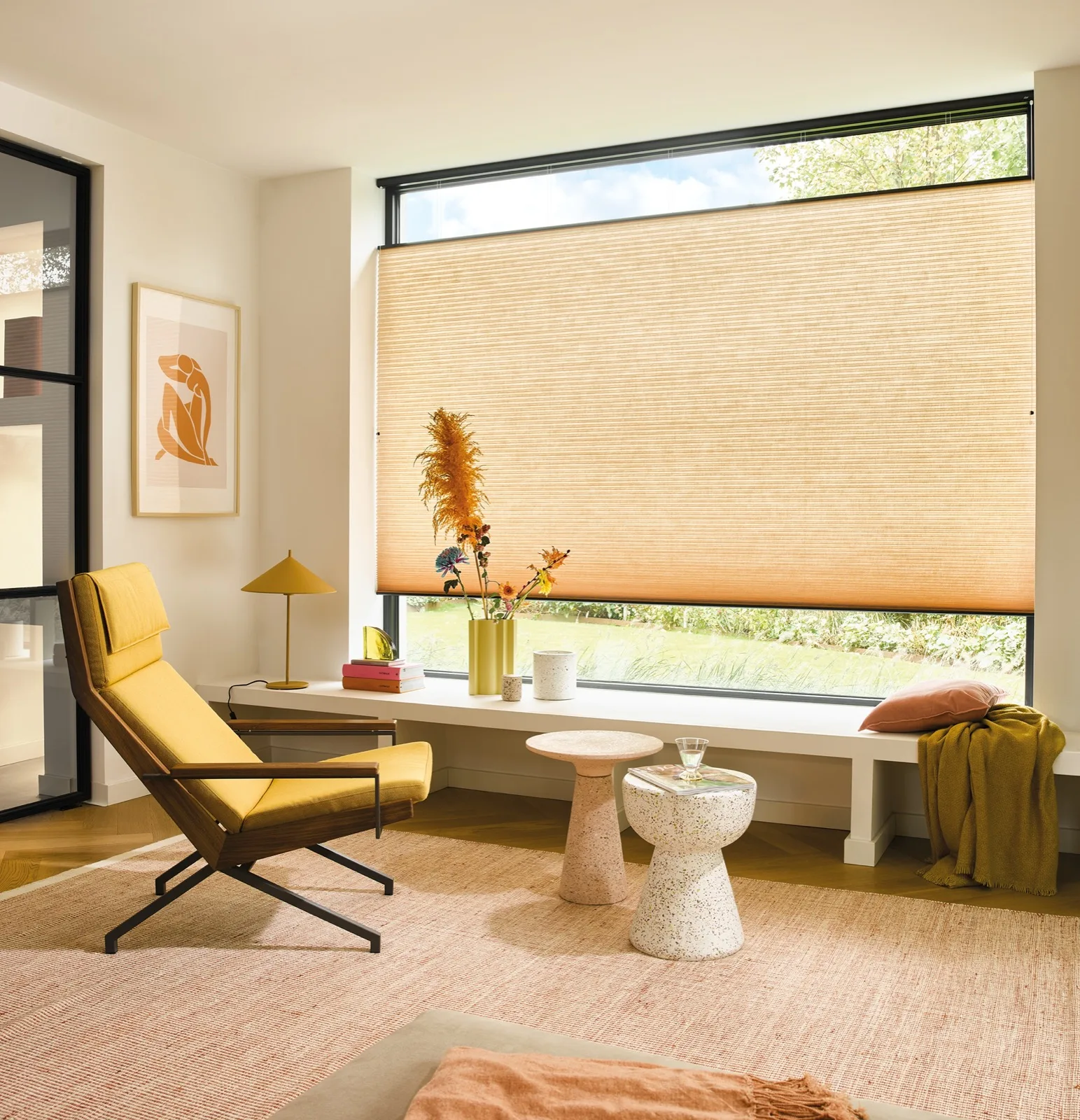 Luxaflex Duette in warm amber beside a yellow mid-century chair